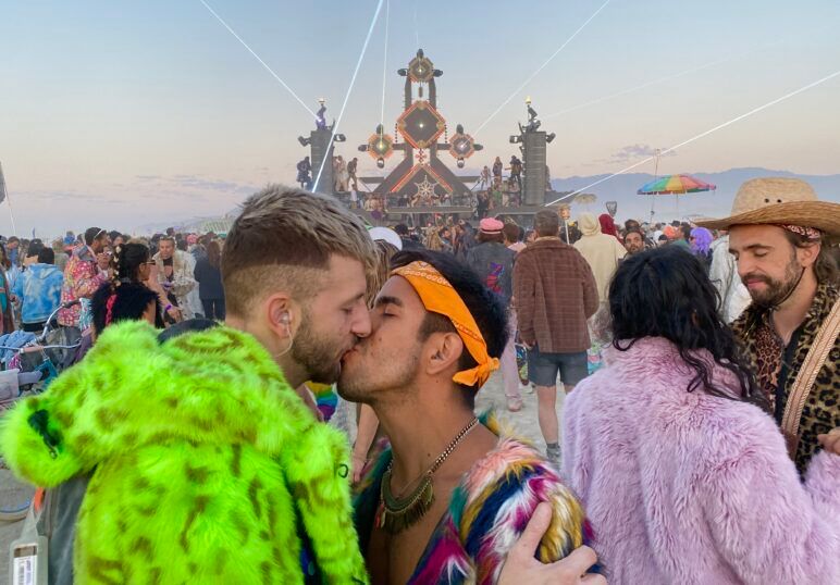 Ryker and Milo sharing a sunrise smooch in front of the infamous Mayan Warrior art car.