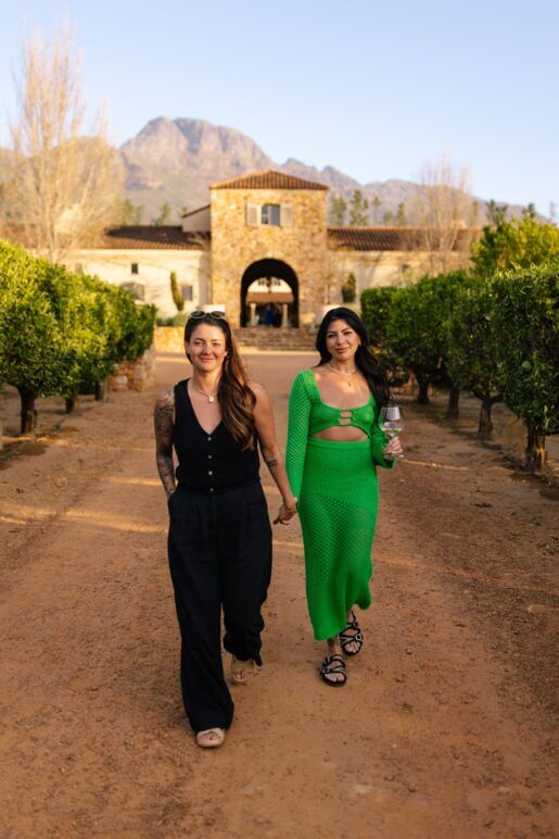 Kirstie Pike and Christine Diaz walk hand-in-hand among the expansive garden at Waterford Estate, South Africa.
