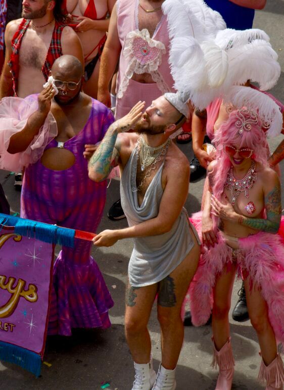 Some stylish queens in Vegas showgirl outfits fabulously walk down the parade route