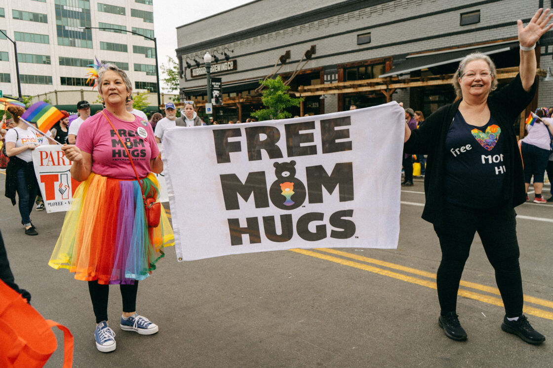 Two women holding a banner that says "Free Mom Hugs" march in Boise Pride parade