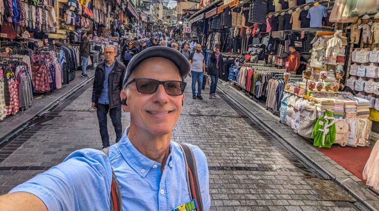 Michael standing on a busy street in Fatih. Michael Jensen stands in the iddle of an outdoor market