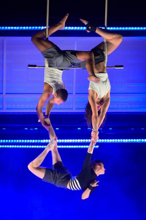 Performers at Club Fugazi suspended from a trapeze. 