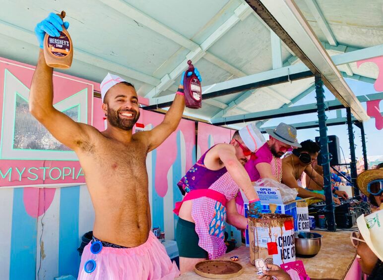 Rashad of the queer camp Mystopia, clad in his pink tutu, as he helps serve guests ice cream cones.