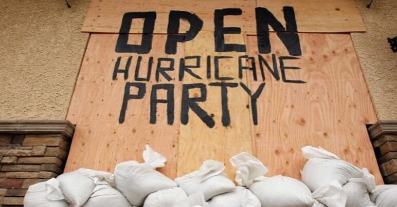 A handpainted sign on plywood advertises a "Hurricane Party" at Phoenix Bar in New Orleans.