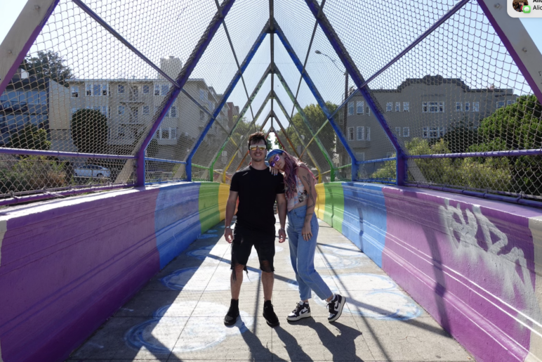 The author and Monica posing at the rainbow bridge in Dolores Park. 