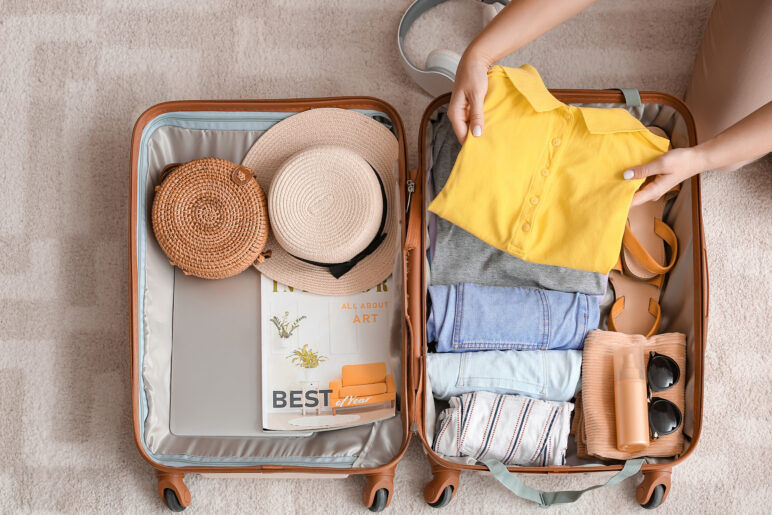 Woman packing suitcase at home.