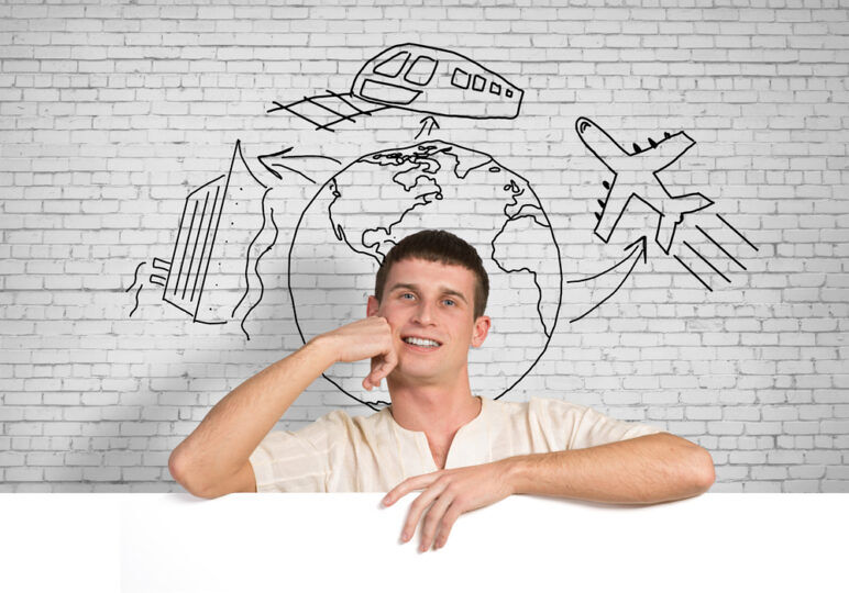 A young man stands in front of travel illustrations 