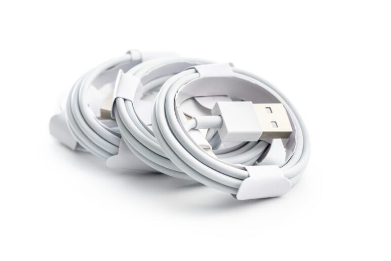 Several neatly coiled white USB charging cables, stacked on top of one another, ready for use.