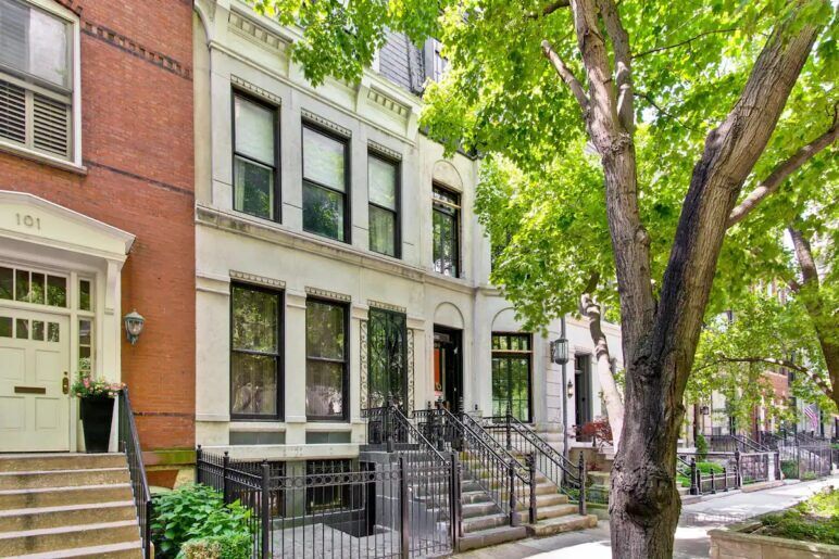 The facade of a white townhouse faces the street