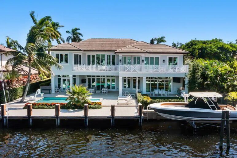 A waterfront villa with a speedboat docked out front