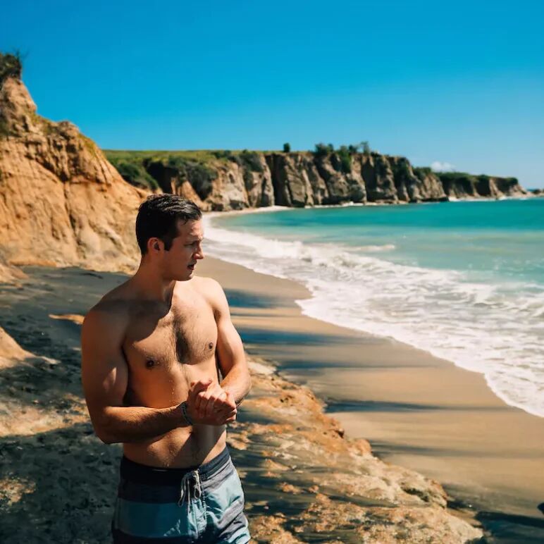 A shirtless man standing on beach in San Juan, Puerto Rico. 