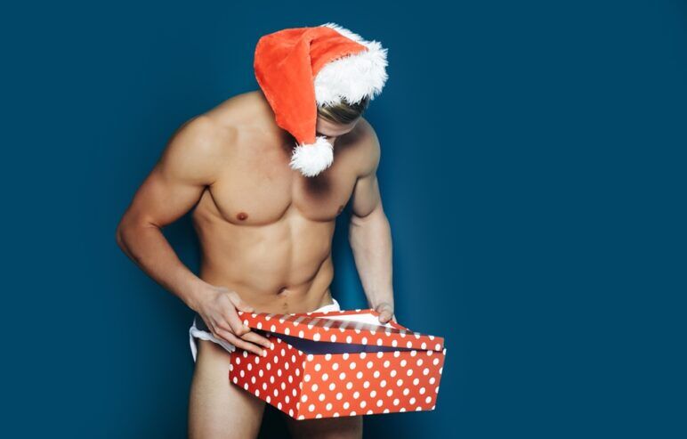 Handsome sexy santa claus guy on blue background