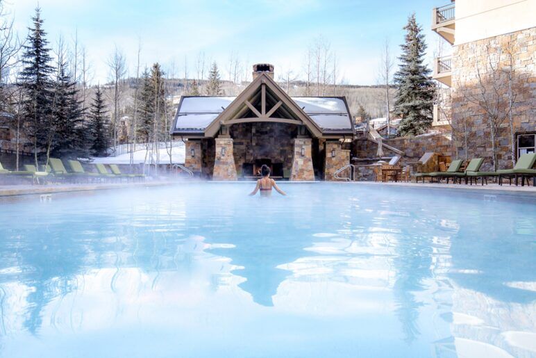 A woman relaxes in an open-air hot spring bath