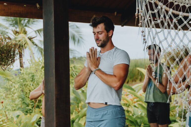 Joe Santini in a white crop top and shorts doing yoga at last year's retreat.
