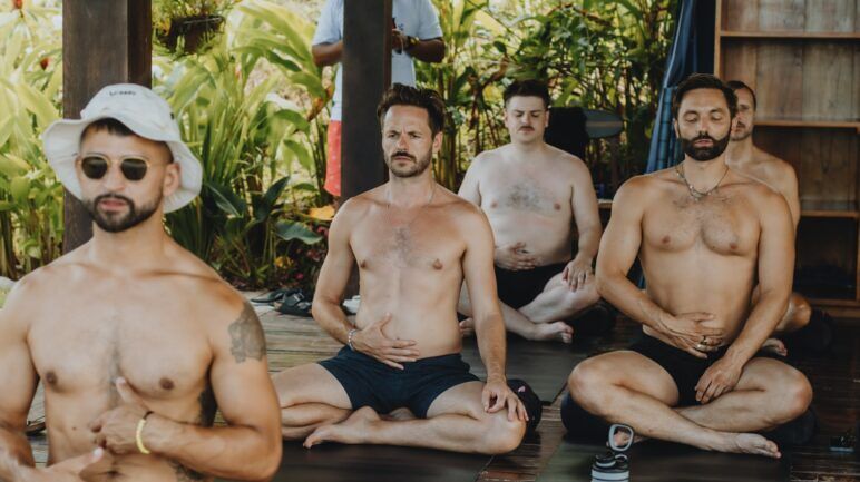 Five gay shirtless men doing yoga at Gay Surf Week. 