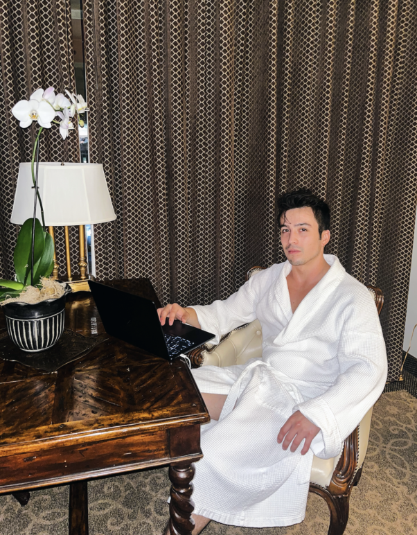 A photo of author Jamie Valentino sitting at a desk in a hotel suite at the O.Henry Hotel in Greensborough. 