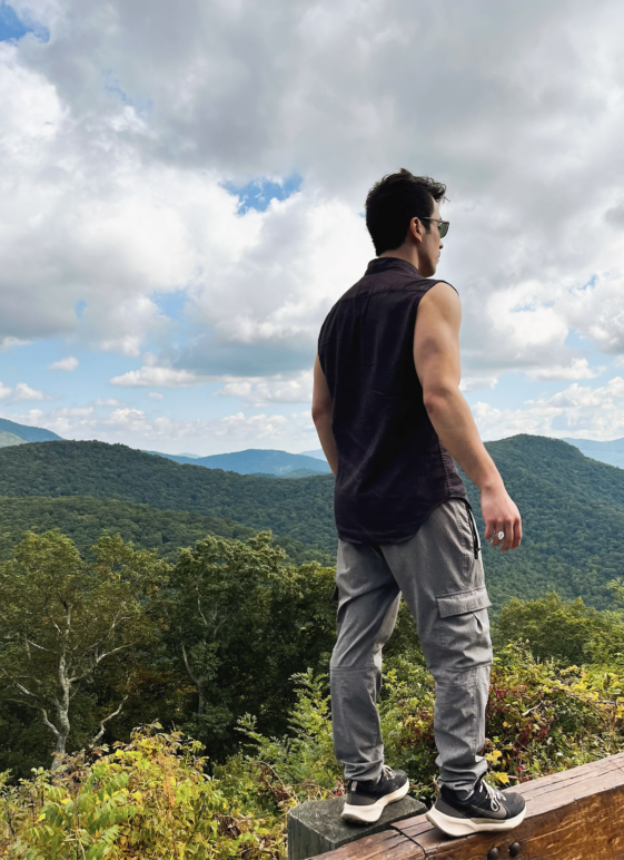 A photo of the author standing on a rail with the Blue Ridge Mountains as the backdrop. 