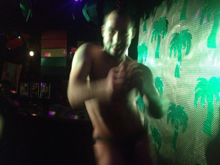 A man in a thong dances in a nightclub
