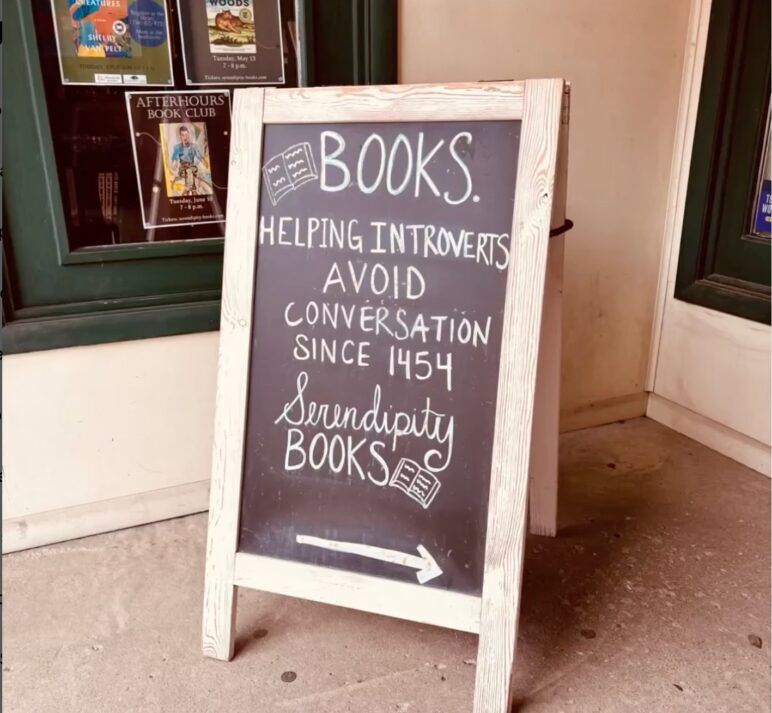 A sign outside a bookstore reads "Books: Helping introverts since 1454."