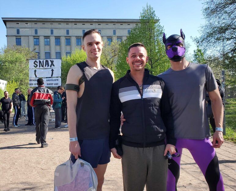 Three men stand outside the entrance to Berghain, ready to enter the Snax party.