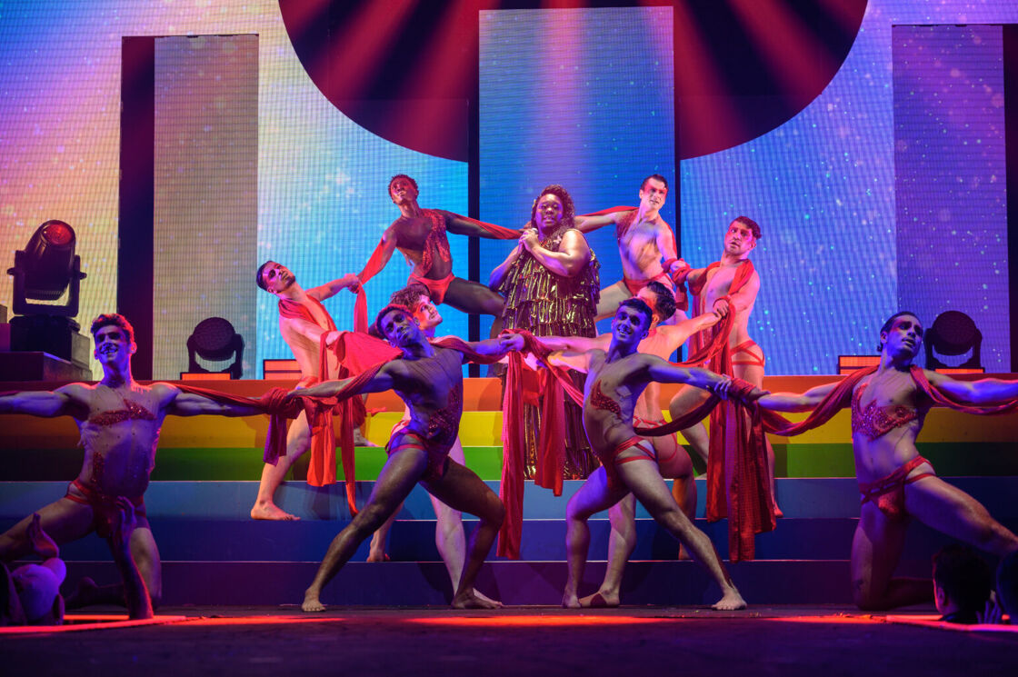 Alex Newell performs in a golden dress at Broadway Bares.