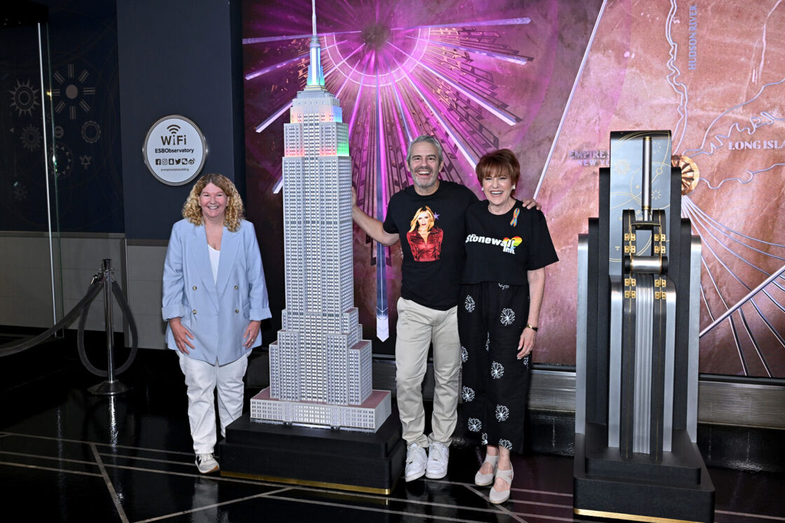 Stacy Lentz, Andy Cohen, and Lorna Luft pose next to a model of the Empire State Building.