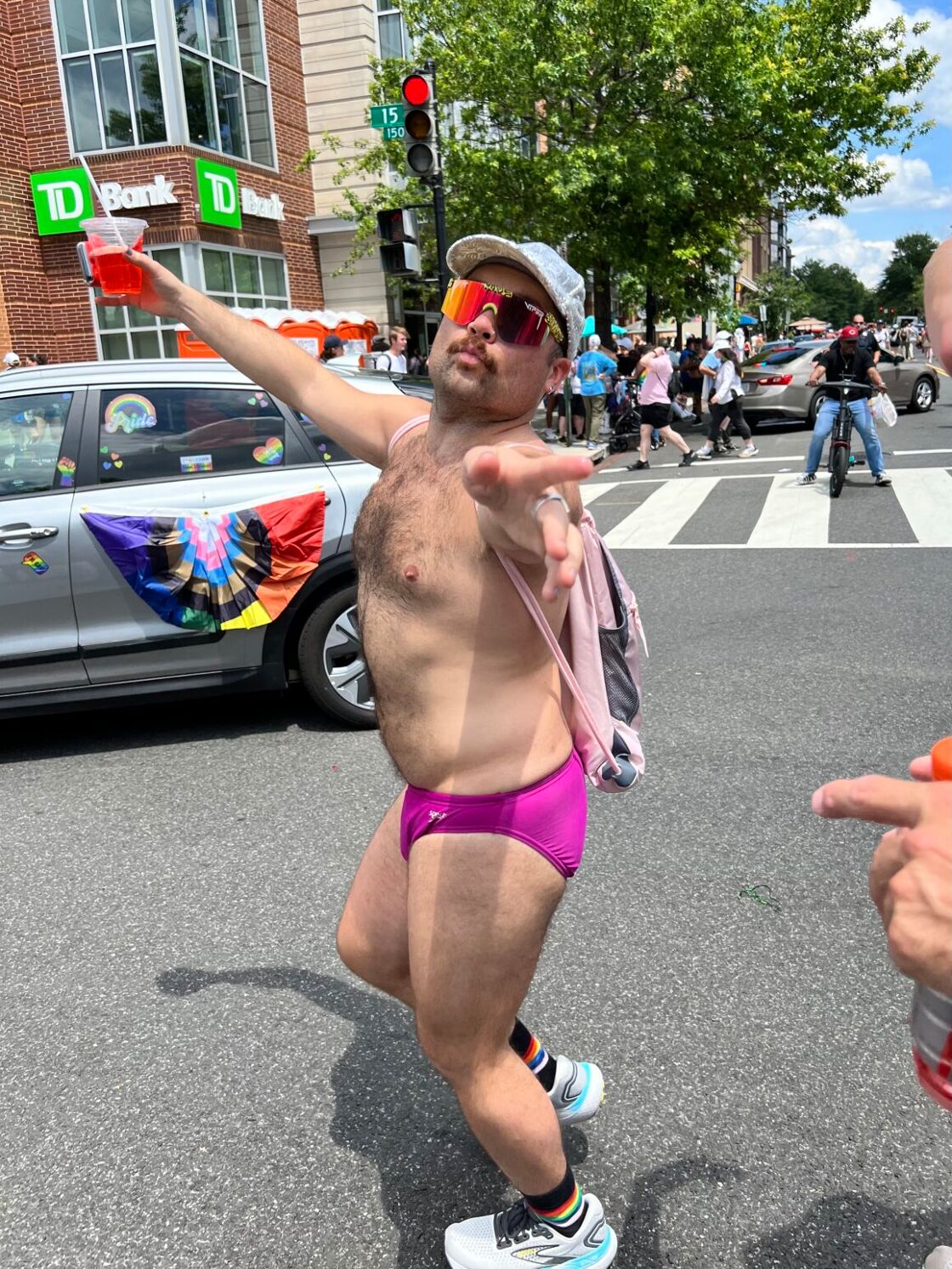 A man wearing only a pink speedo struts down the street