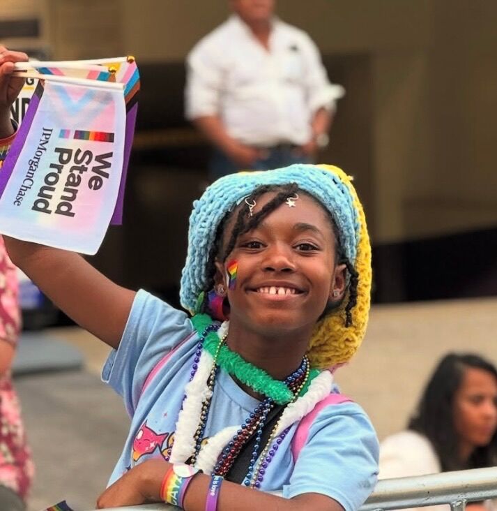 An adorable child shows support for LGBTQ+ community at the pride parade.