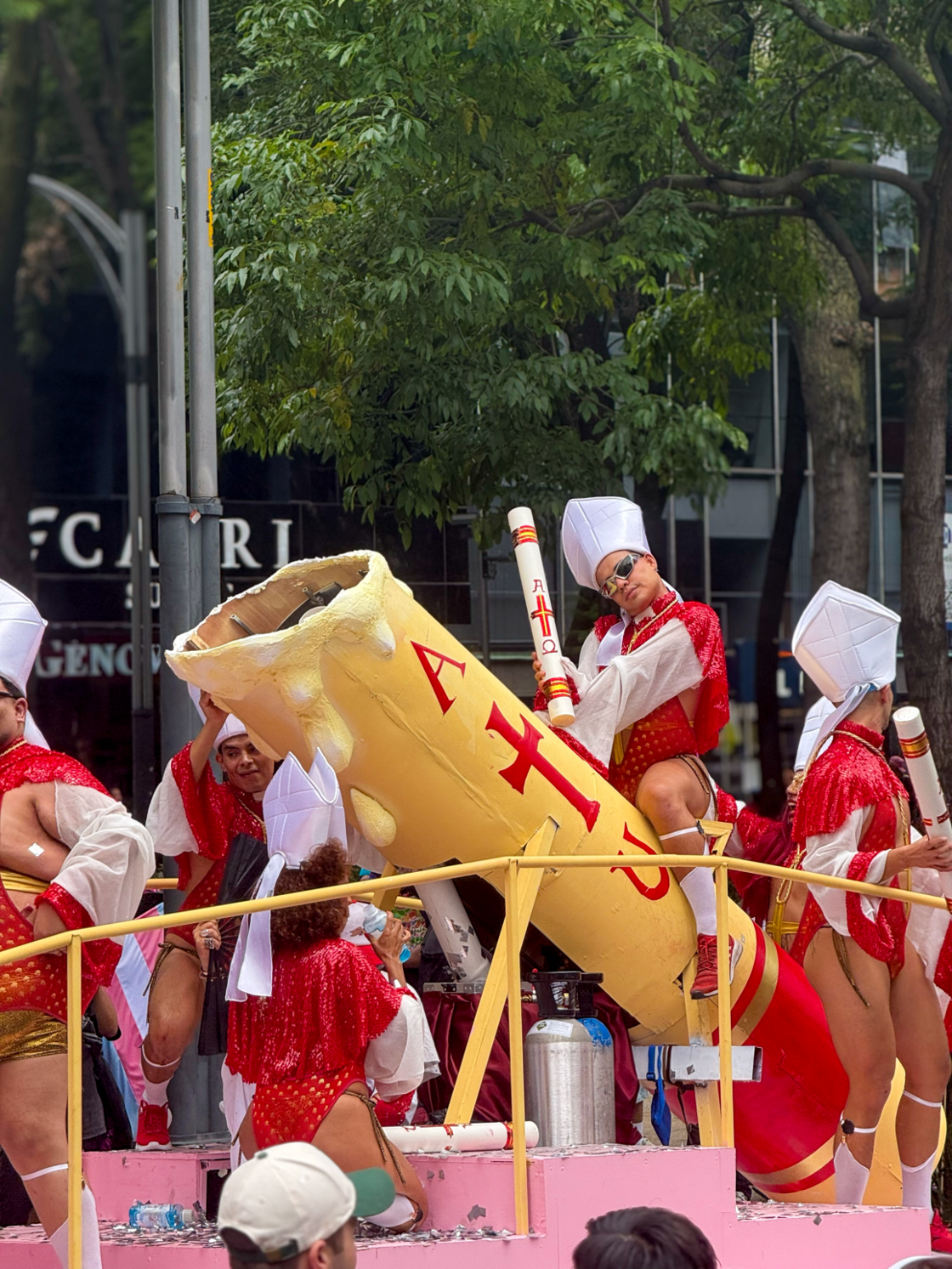 A Mexico City Pride parade float featuring attendees dressed in church regalia waving candles.