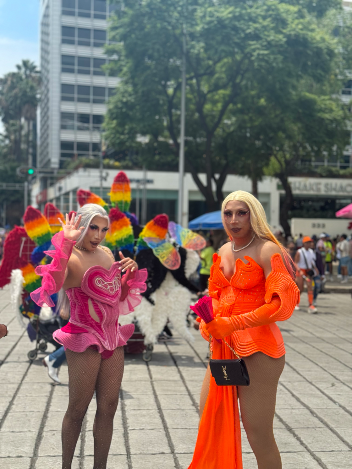 Two drag queens smile and wave at Mexico City Pride.