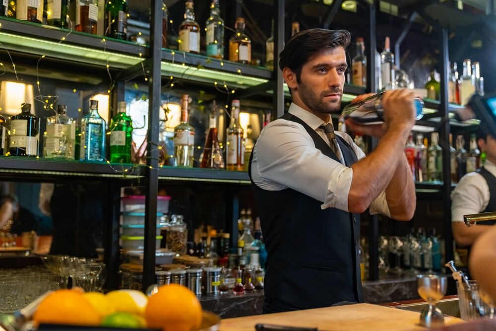 A bartender shakes a drink