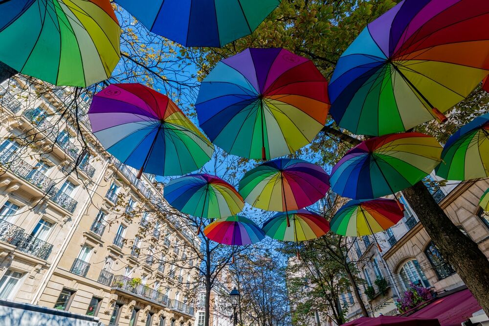 Paris, France 10 11 2024: A parisian terrace: "Le JU" on Archive street in the center of Paris decorated with beautiful rainbow colored umbrellas used as decoration, in Paris Gay quarter