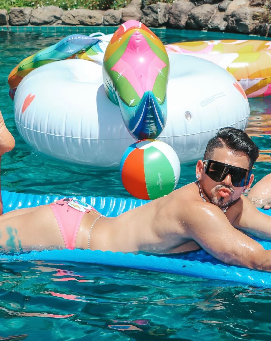 A young man lounges on a pool floatie at the Gay Wine Weekend pool party.