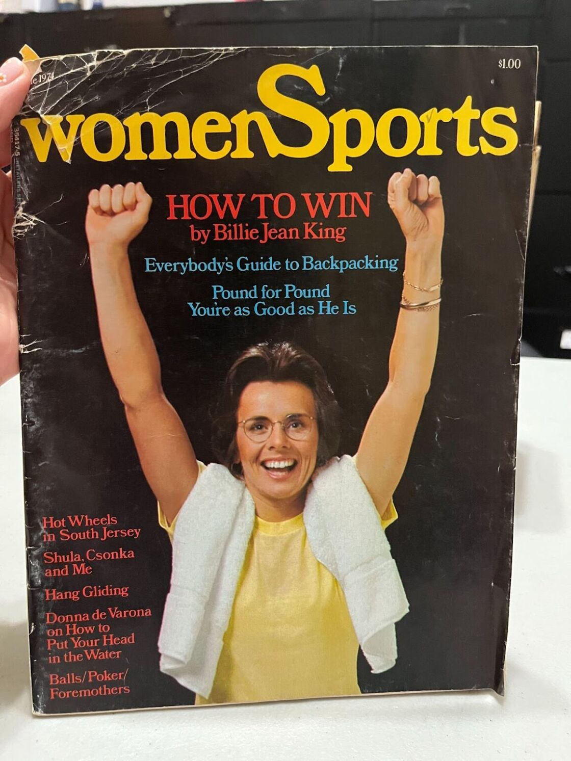 The cover of a vintage copy of "Women Sports," featuring Billie Jean King standing triumphantly.