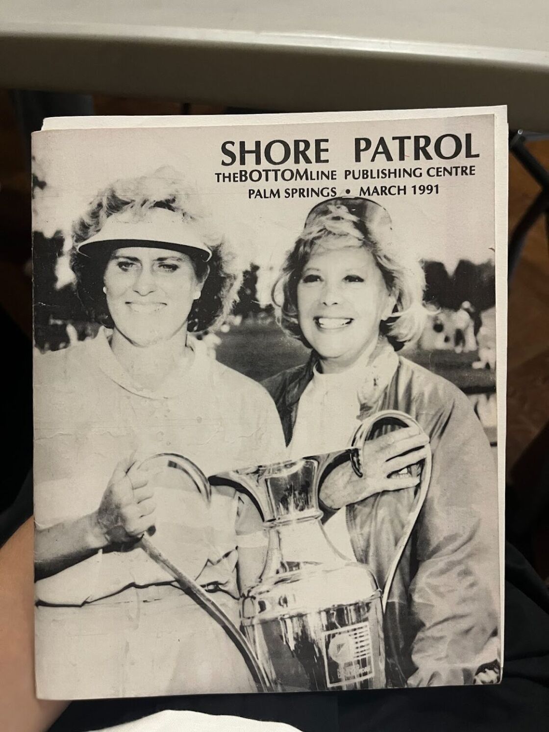 The cover of Palm Springs publication "Shore Patrol" in March 1991, depicting two women holding a trophy on the cover.