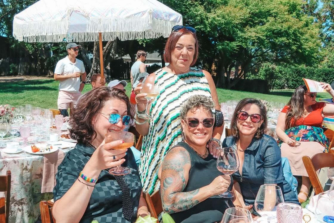 A group of ladies hold up their glasses for a toast at Gay Wine Weekend.