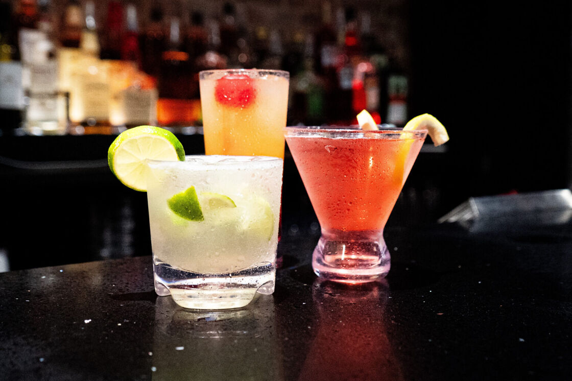 Three drinks in elevated glasses are pictured on the counter at The Ritz Bar & Lounge.