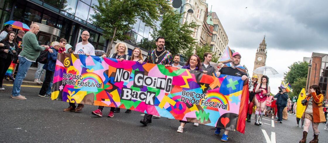 Marching with a banner at Belfast Pride Parade 2025