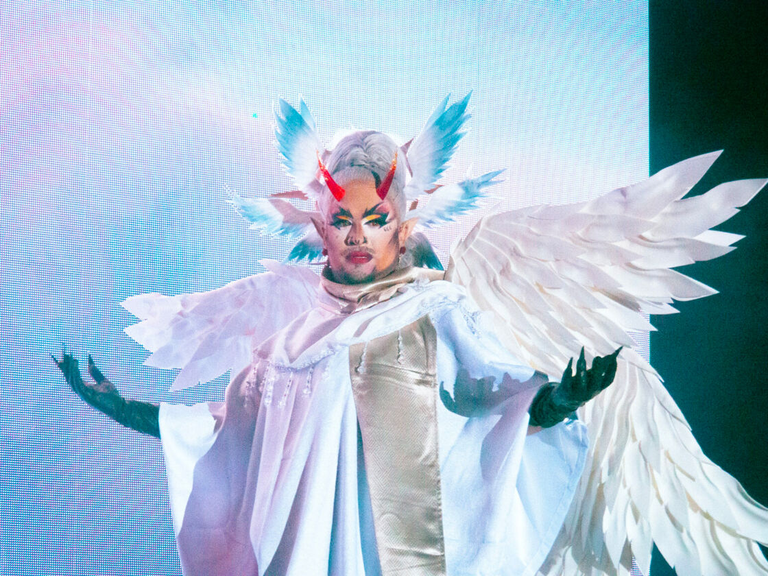 Megami dances in a white angelic dress with wings at Bushwig.