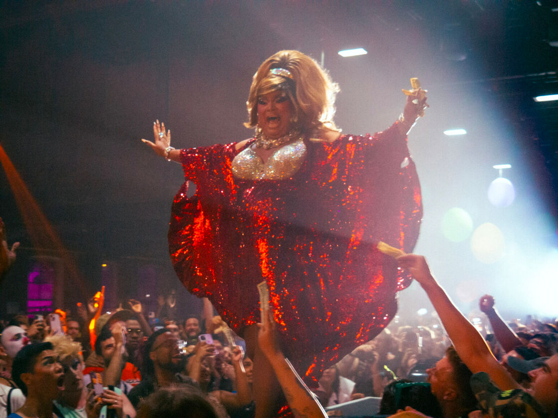 Lushious Massacr performs in a shining red dress at Bushwig.
