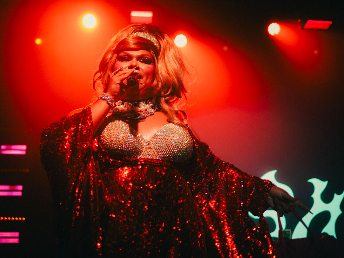 Lushious Massacr performs in a shining red dress at Bushwig.