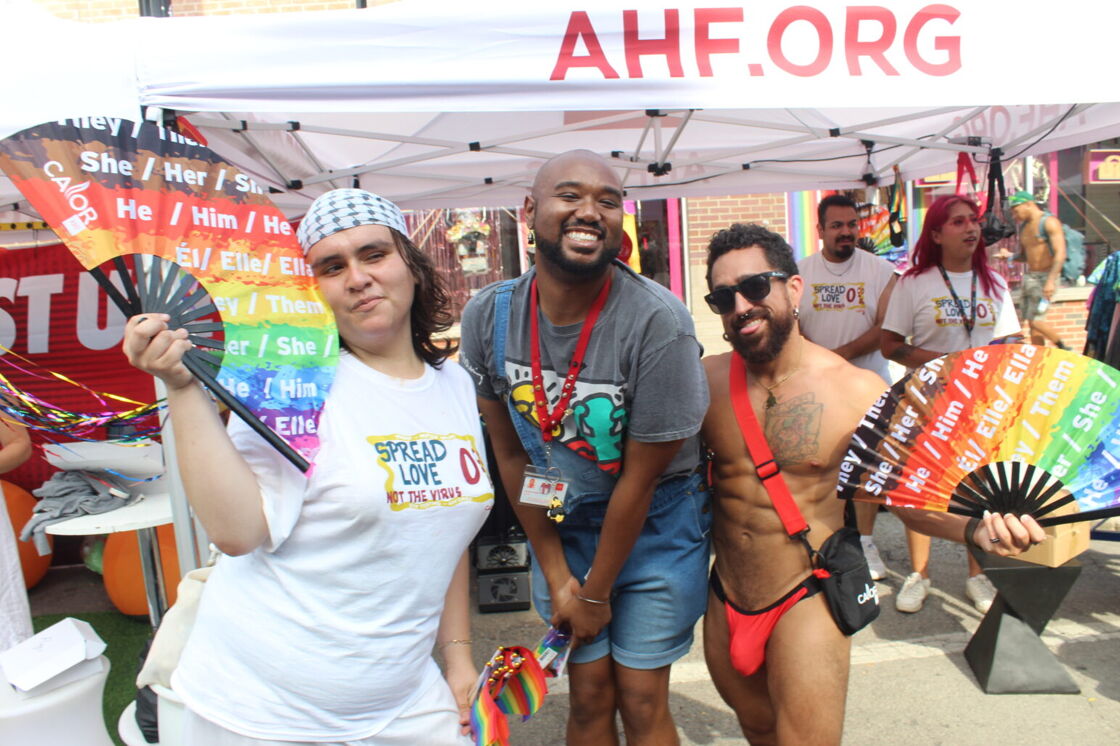 A group of festivalgoers pose with fans outside the AHF booth at Chicago's Market Days.