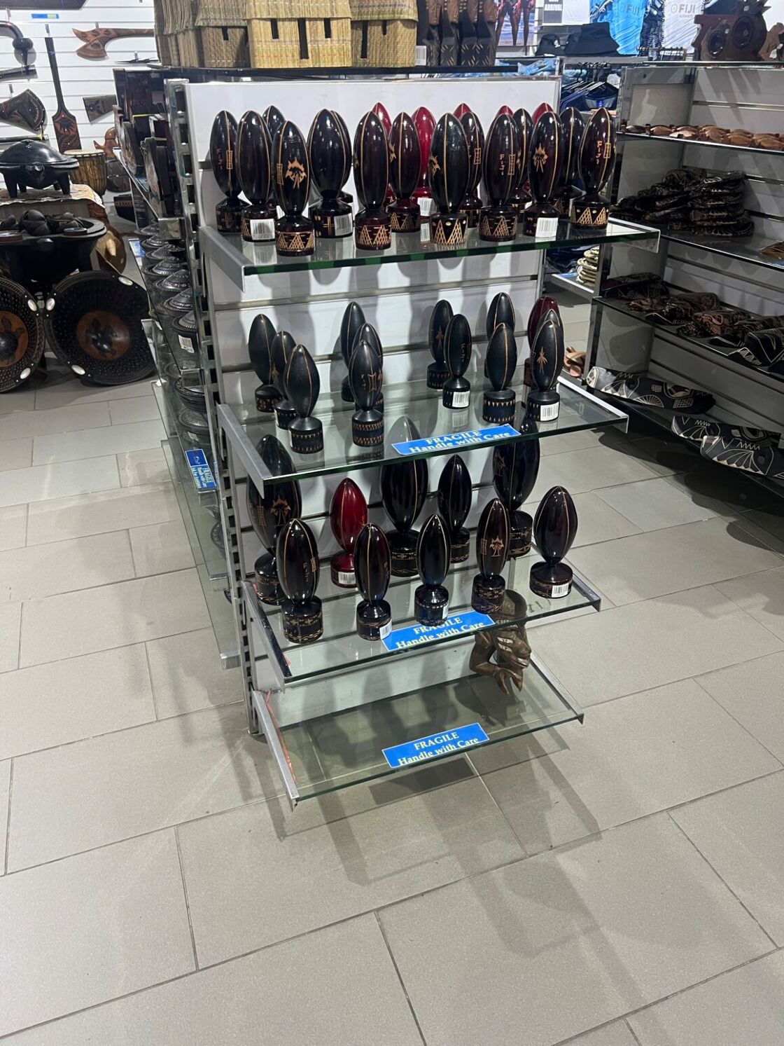 A rack of shelves in a Fiji gift shop displaying rows and rows of rugby statuettes.