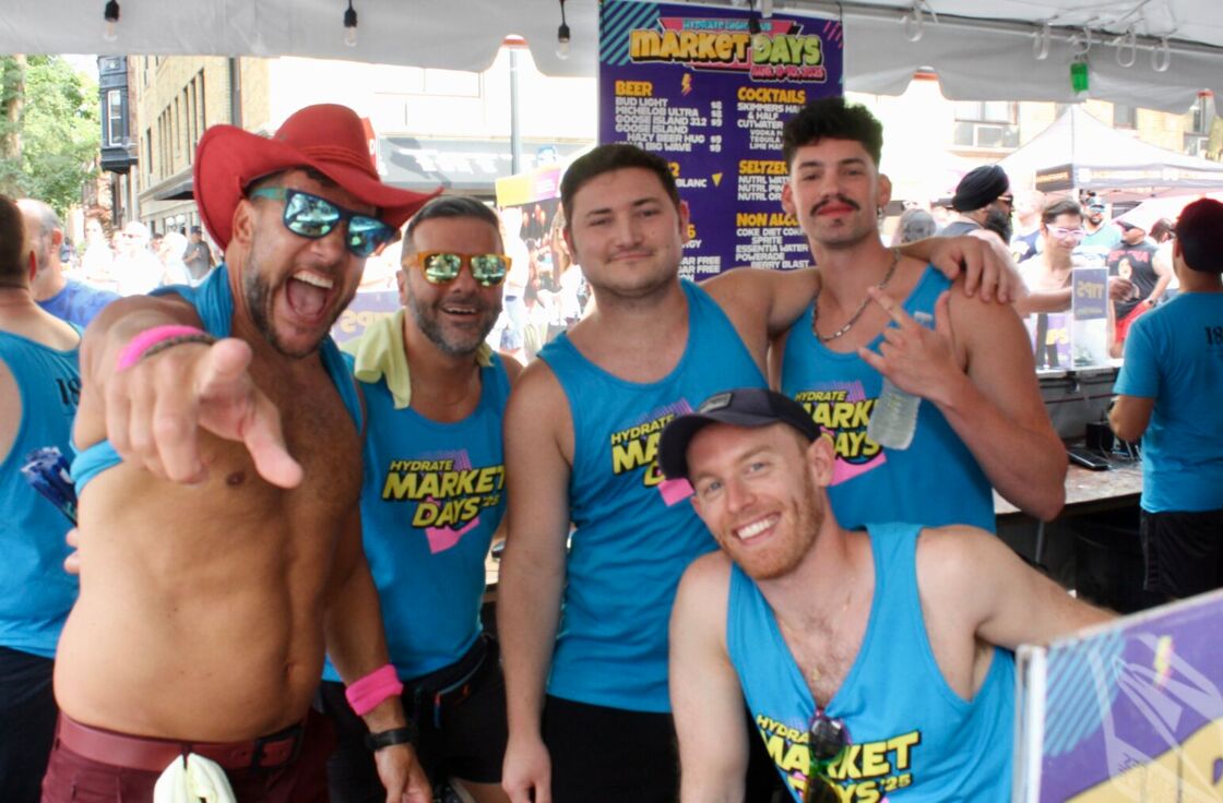 A group of bartenders in tanktops pose and smile outdoors at Chicago's Market Days.