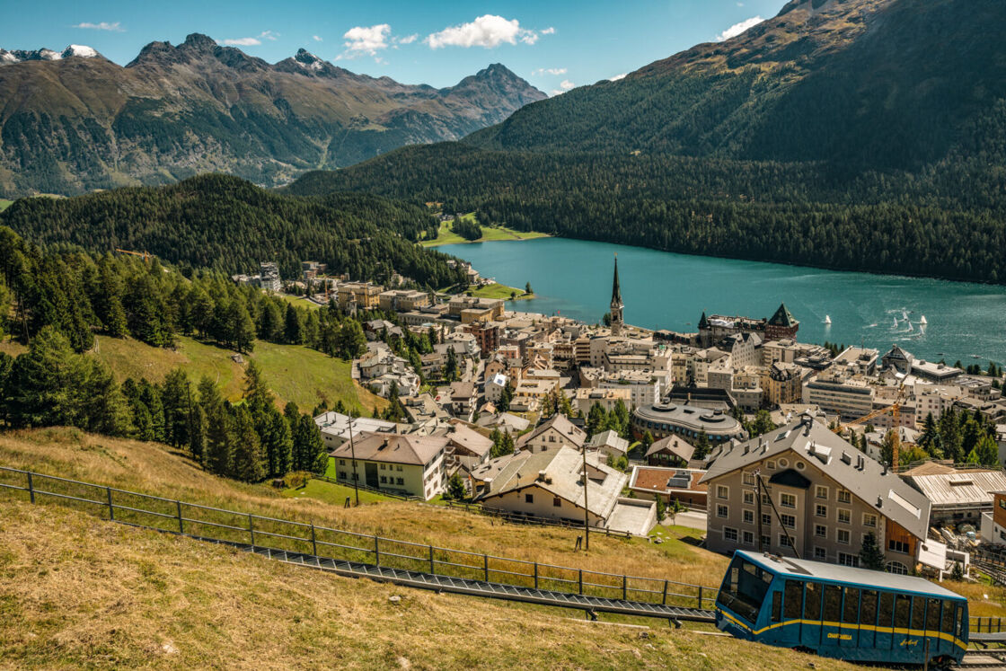 St. Moritz, featuring a lake and mountain, pictured during the daytime in the summer.