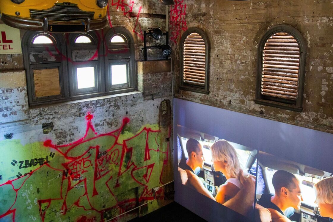 A projection of women kissing inside The Substation at Qtopia Sydney.
