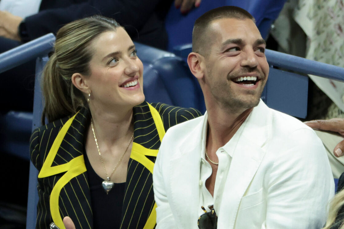 Matt Rogers sits next to a friend and laughs in the crowd at the US Open.
