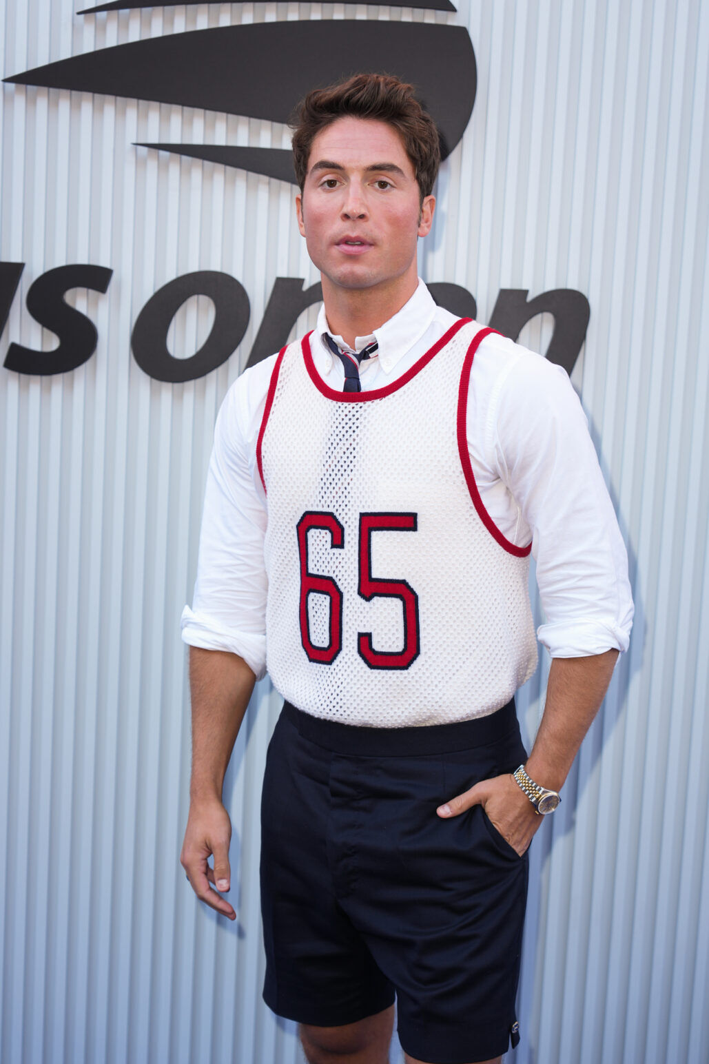 Benito Skinner poses in a jersey over a long sleeved white t-shirt at the US Open.