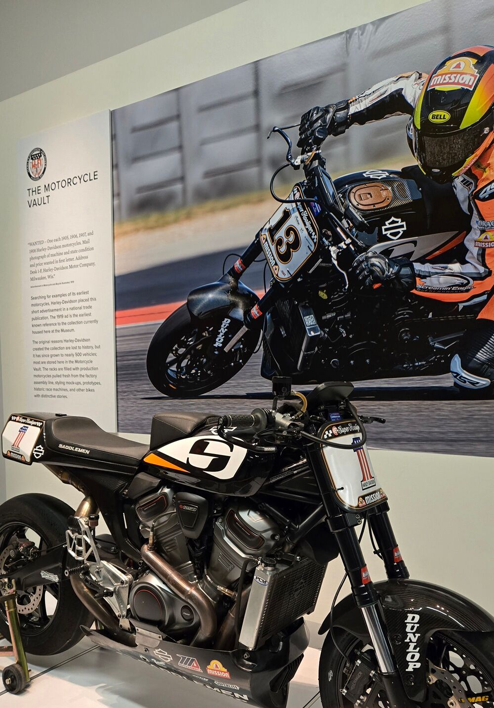 A motorcycle on display at the Harley-Davidson Museum in Milwaukee, in front of a sign reading "The Motorcycle Vault."