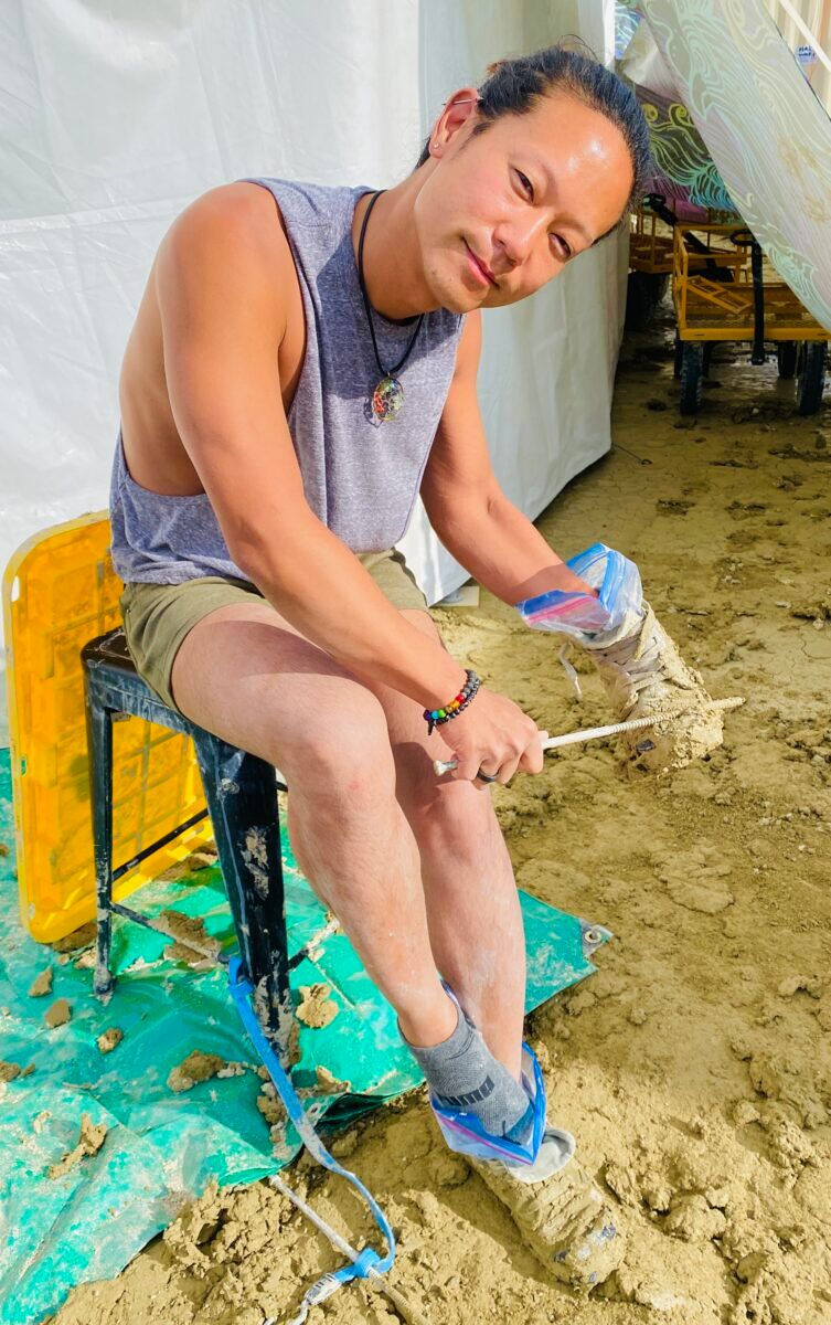 DC-based Burner Patrick Kim scrapping Playa mud from his boots